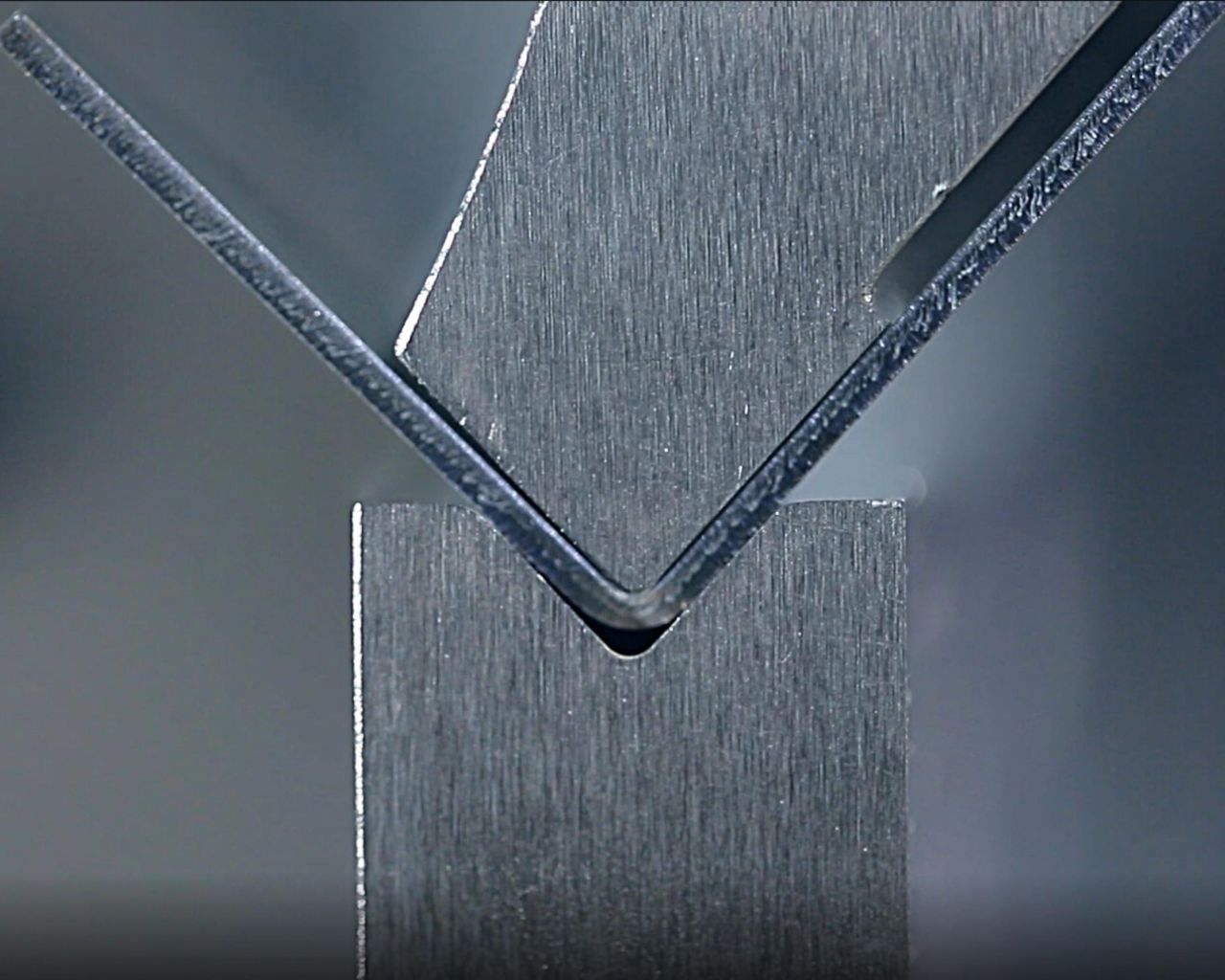 Close-up of a press brake bending sheet metal with precision - CNC press brakes in use.