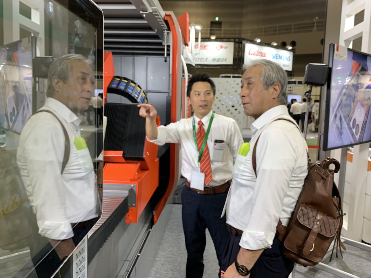 Bystronic salesman explains something to a trade fair guest