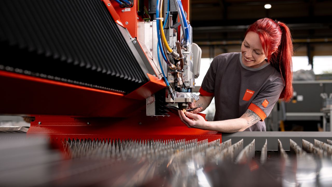 Woman with red hair repairs a machine