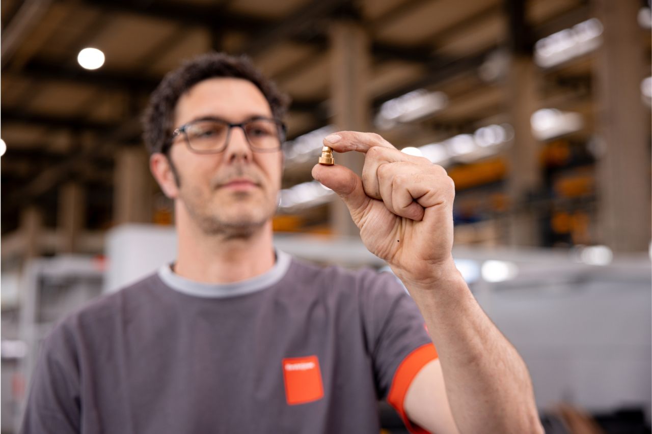 Man with glasses examines a small object