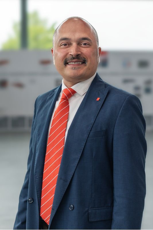 Smiing bold man with dark moustache and blue suit