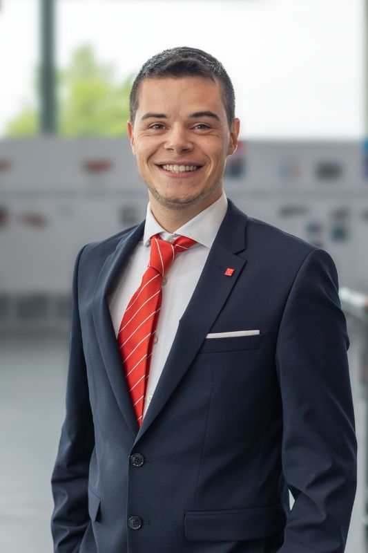 Smiling man with brown hair and blue suit