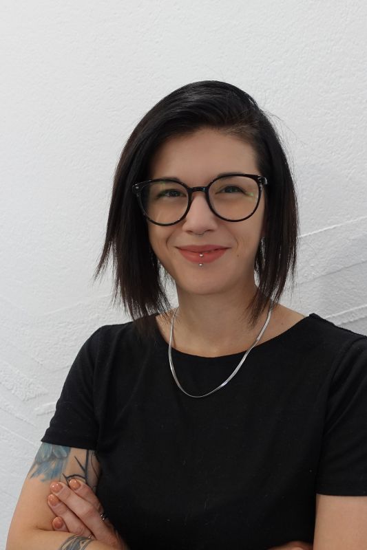 Smiling lady with short black hair and glasses