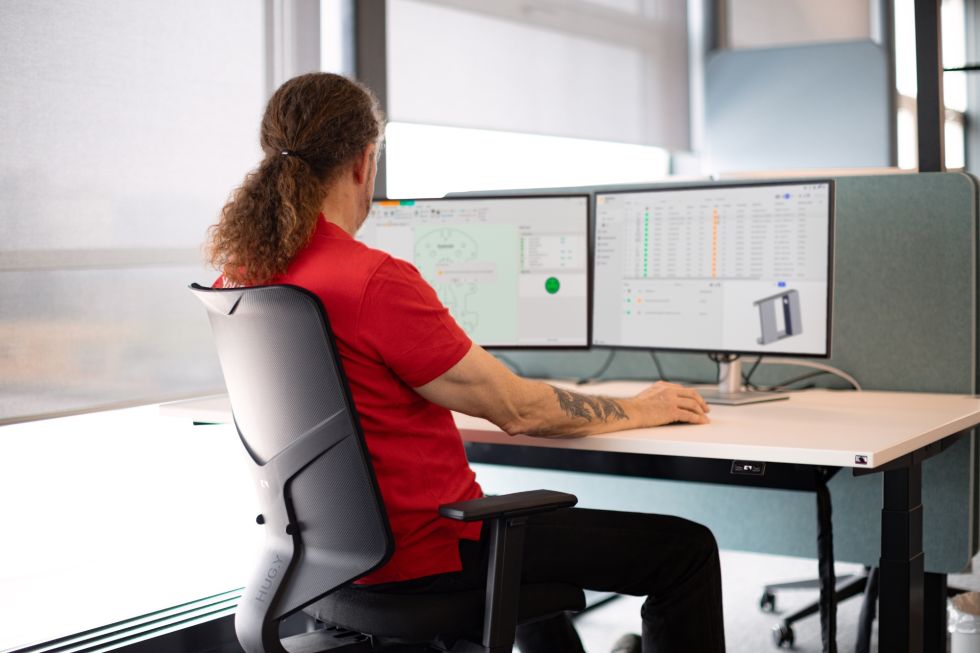 man with red shirt is working on a computer