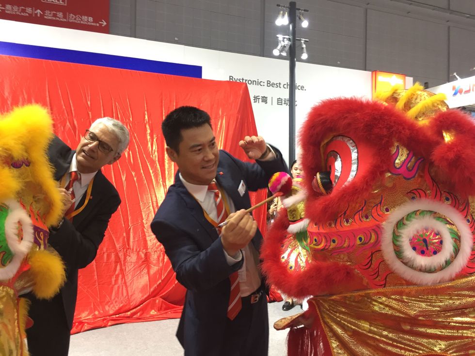 Jean-Pierre Neuhaus, Head of Corporate Communications, and You Song, President of Bystronic Group China, paint the eyes of the lion and the tiger. This is an ancient Chinese tradition. For good luck, a lion dance is a must at every major event. The veiled Xpress can be seen in the background.
