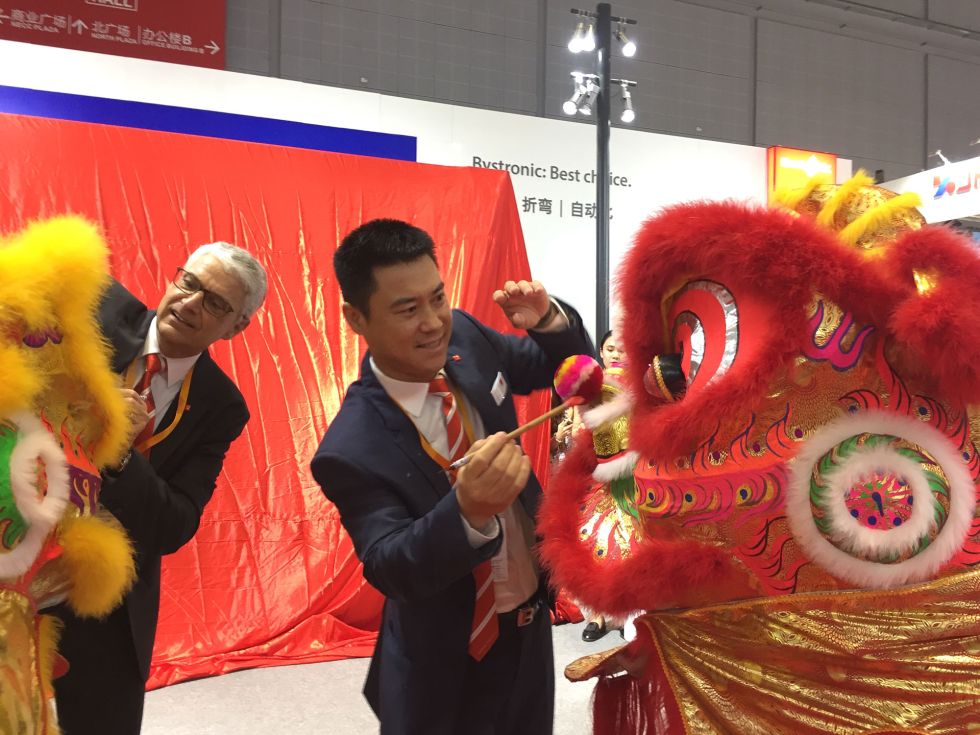 Jean-Pierre Neuhaus, jefe de comunicación empresarial y You Song, presidente del grupo Bystronic en China, pintan los ojos del león y del tigre. Se trata de una antigua tradición china: En cualquier evento que se precie, no debe faltar la danza del león para atraer la suerte. Detrás se encuentra la Xpress, aún sin desvelar.