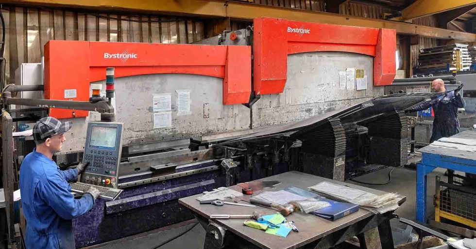 The two Bystronic press brakes being used in tandem to fold a large sheet metal panel.