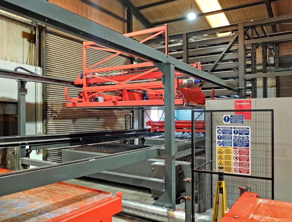 One of a pair of handling carriages serving the storage system transferring a machined sheet to a twin offload table arrangement at the back of the ByStar Fiber. The carriage in the background simultaneously picks a new sheet from the store and loads it onto the shuttle table of the machine, so little laser cutting time is lost.
