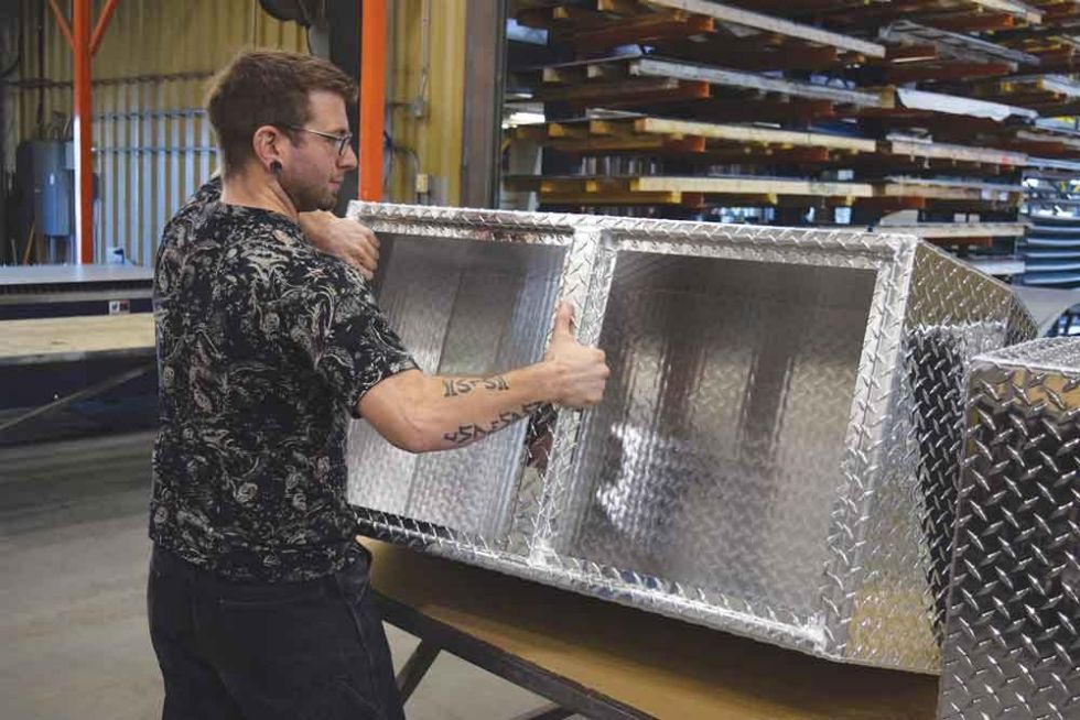 Programmer Randy Mullin with a diamond plate assembly on the shop floor.